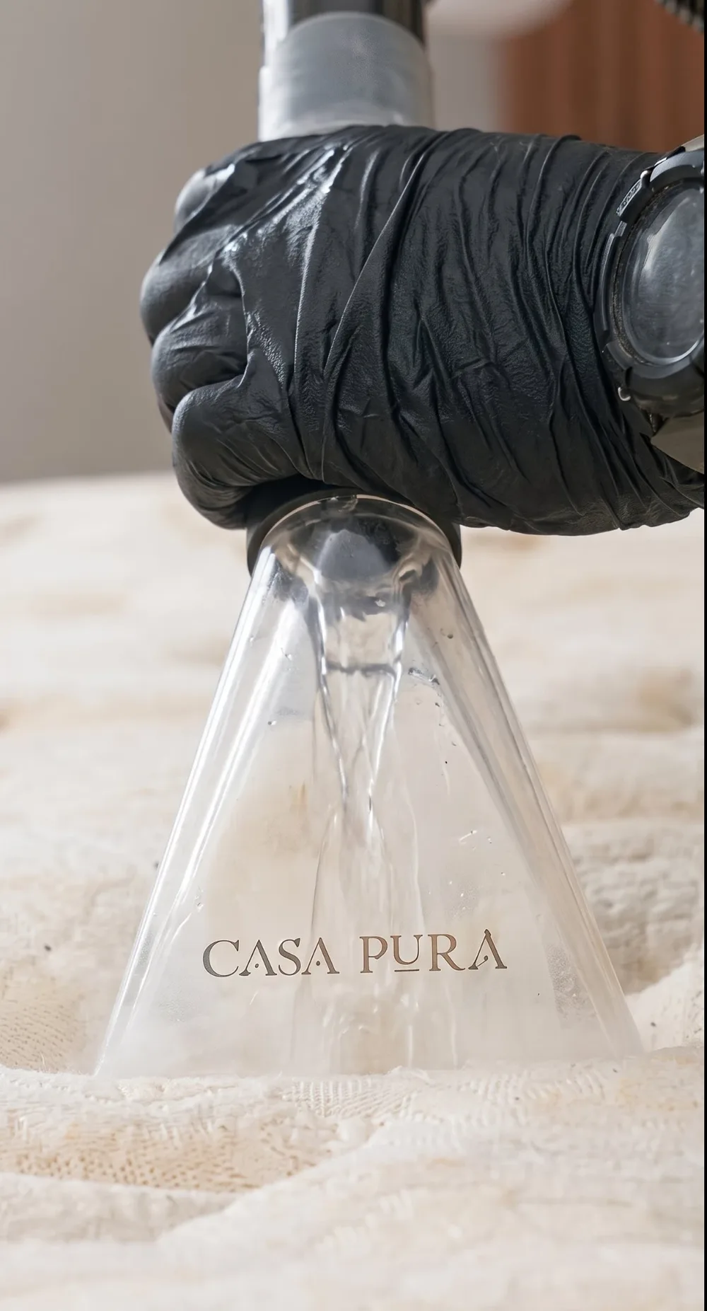 Equipamento Casa Pura em atendimento sobre tecido, com a mão do profissional